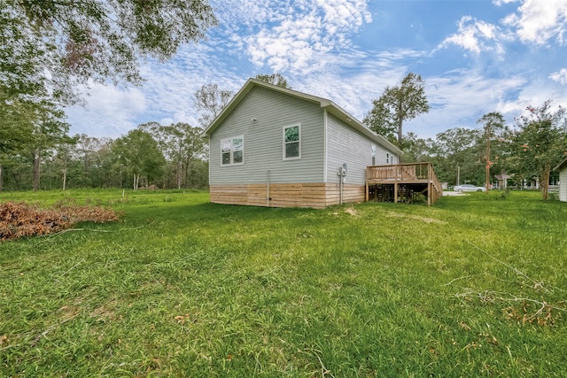 view of side of property featuring a lawn and a wooden deck