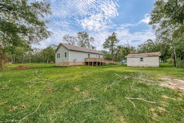 view of yard featuring a wooden deck and an outbuilding