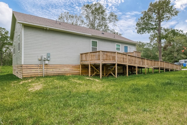 rear view of house with a lawn and a wooden deck