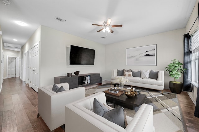 living room with ceiling fan and dark wood-type flooring