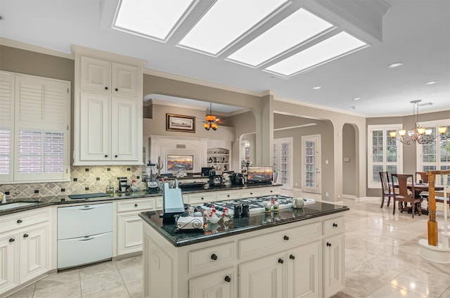 22222 Holly Creek Trl, Tomball, TX 77377 - kitchen featuring arched walkways, a chandelier, white dishwasher, backsplash, and pendant lighting