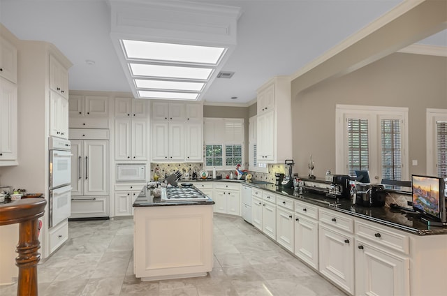 22222 Holly Creek Trl, Tomball, TX 77377 - kitchen featuring dark countertops, a peninsula, white appliances, crown molding, and backsplash