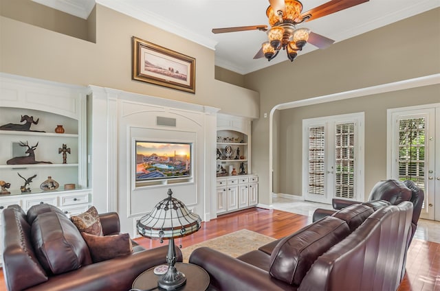 22222 Holly Creek Trl, Tomball, TX 77377 - living room featuring french doors, a ceiling fan, built in features, ornamental molding, and wood finished floors