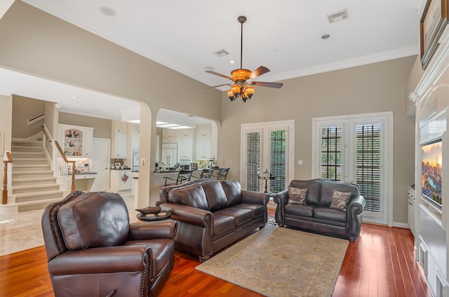 living room with french doors, dark hardwood / wood-style floors, ornamental molding, and ceiling fan