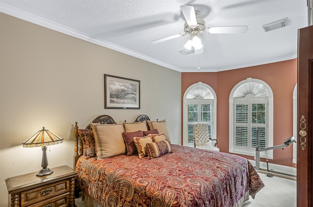 bedroom featuring ceiling fan, a textured ceiling, light carpet, and ornamental molding