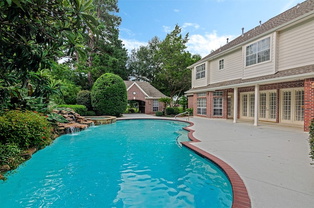 view of pool featuring french doors, a patio, and an in ground hot tub