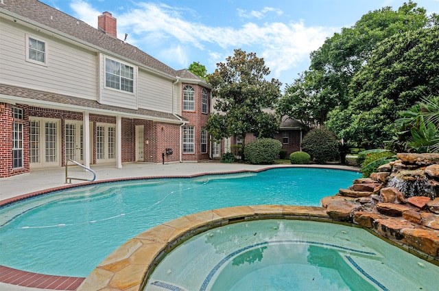 view of swimming pool with an in ground hot tub, french doors, and a patio area