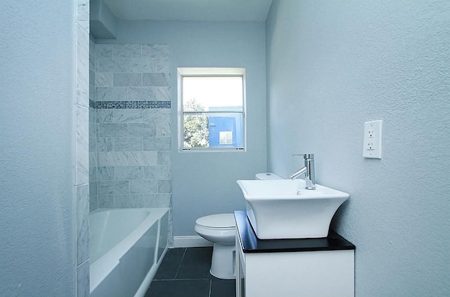 bathroom with vanity, toilet, tile patterned floors, a textured wall, and baseboards