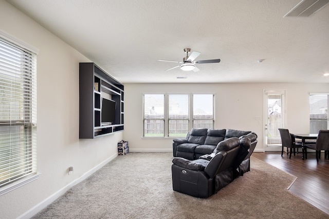 living room featuring plenty of natural light, a textured ceiling, and ceiling fan