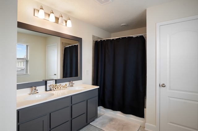 bathroom with walk in shower, tile patterned floors, vanity, and a textured ceiling