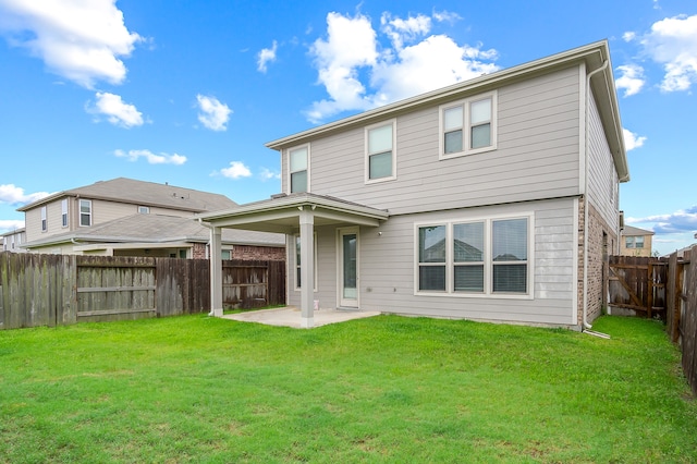 rear view of property featuring a patio and a yard