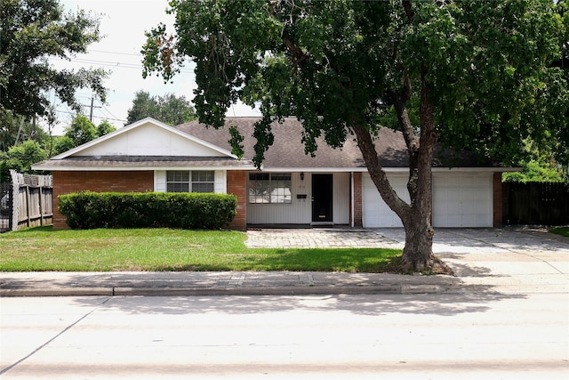 ranch-style home featuring a garage and a front lawn