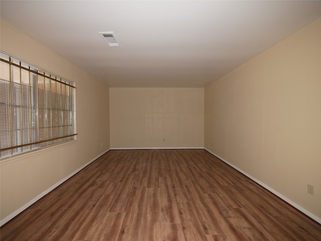 unfurnished room with dark hardwood / wood-style flooring