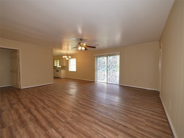 unfurnished living room with ceiling fan with notable chandelier and wood-type flooring