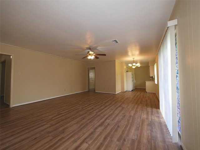 empty room featuring ceiling fan with notable chandelier and dark hardwood / wood-style floors