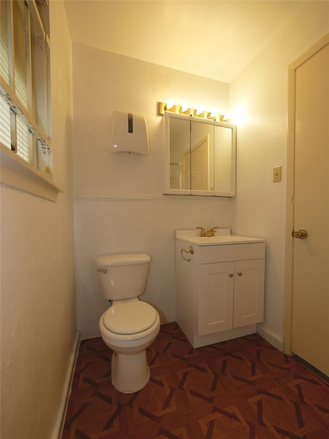 bathroom featuring vanity, parquet floors, and toilet