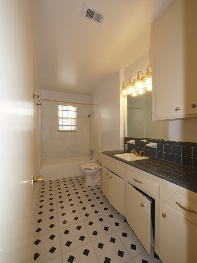 full bathroom featuring vanity, tile patterned floors, tiled shower / bath, toilet, and backsplash