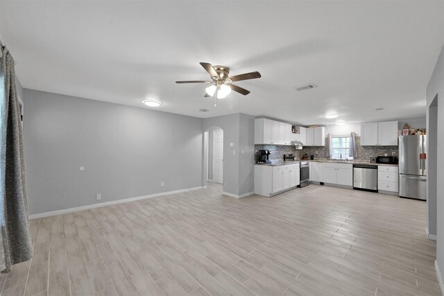 unfurnished living room with sink and ceiling fan