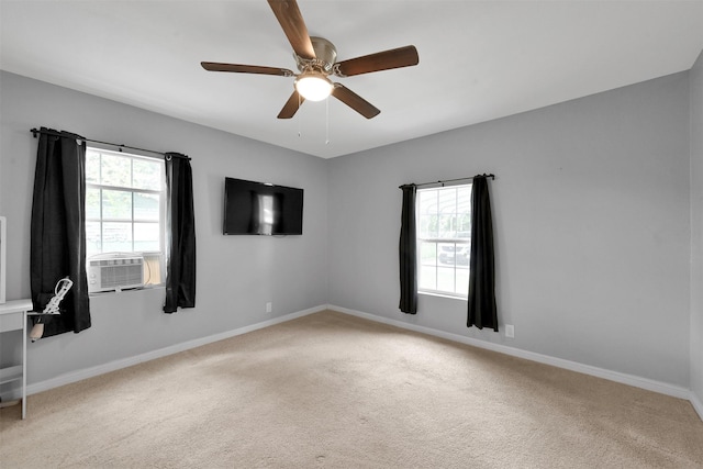 carpeted spare room with cooling unit, plenty of natural light, and ceiling fan