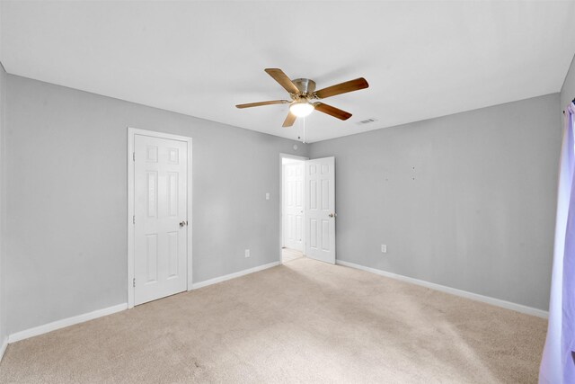 spare room featuring ceiling fan and light colored carpet