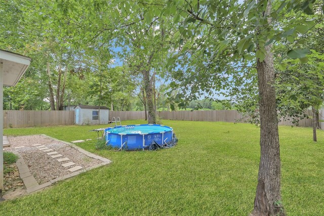 view of yard with a storage unit and a fenced in pool