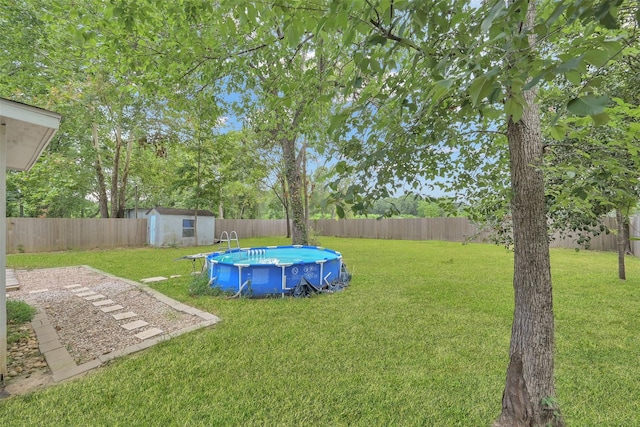 view of yard with a fenced in pool and a storage shed