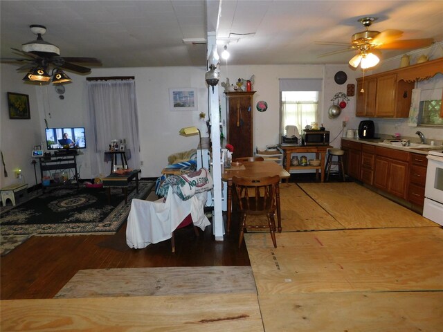 dining space with ceiling fan, light wood-type flooring, and sink