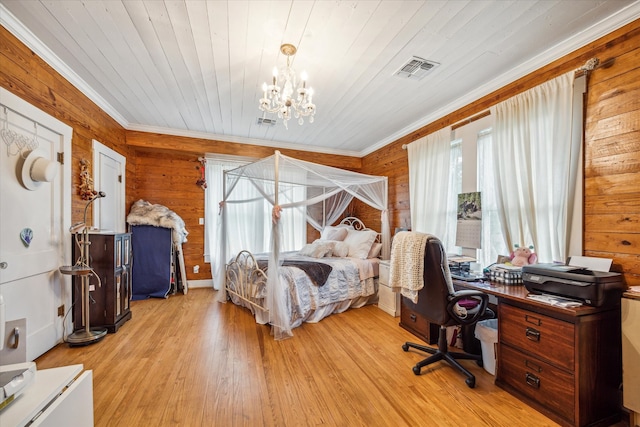 bedroom featuring light hardwood / wood-style floors, wood walls, and crown molding