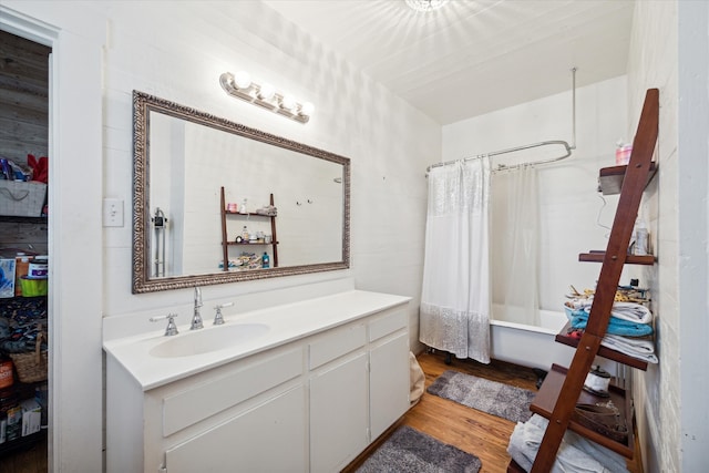 bathroom with shower / bathtub combination with curtain, hardwood / wood-style floors, and vanity