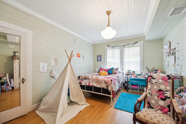 bedroom featuring wood-type flooring and crown molding