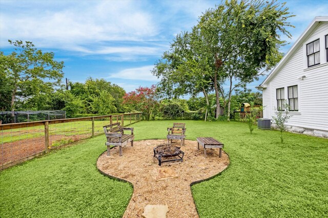 view of yard featuring central air condition unit and a fire pit