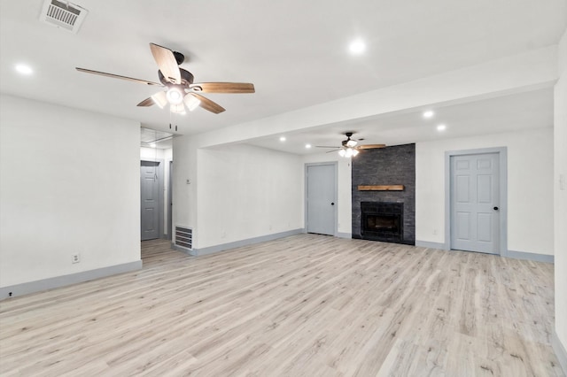 unfurnished living room featuring ceiling fan, a fireplace, and light hardwood / wood-style flooring