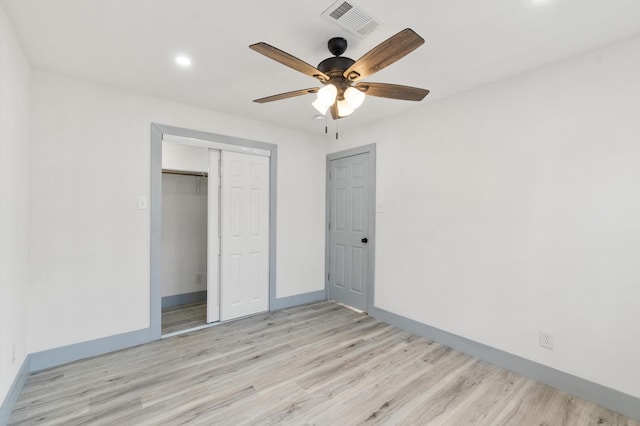 unfurnished bedroom featuring ceiling fan, a closet, and light wood-type flooring