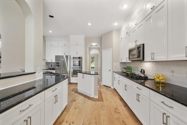 kitchen with white cabinetry, appliances with stainless steel finishes, and dark stone countertops