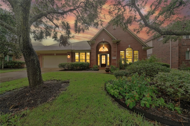 view of front facade with a garage and a lawn