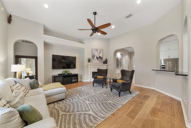 living room featuring ceiling fan and light wood-type flooring