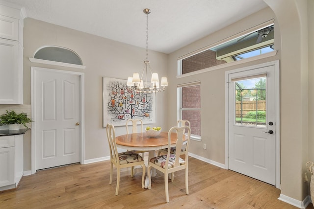 dining room featuring a notable chandelier and light wood-type flooring