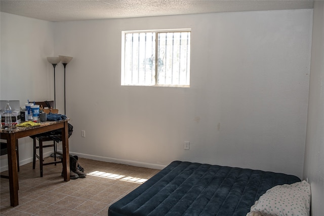 bedroom with a textured ceiling and tile patterned floors