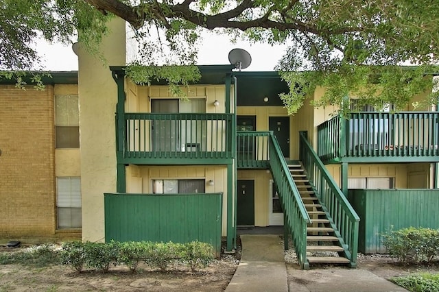 view of building exterior with stairs and fence