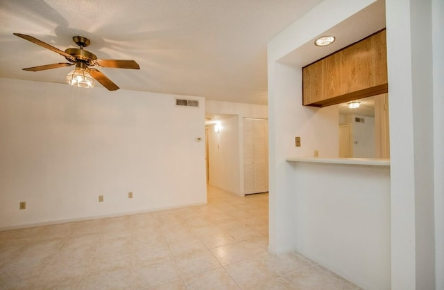 empty room featuring ceiling fan and tile patterned flooring