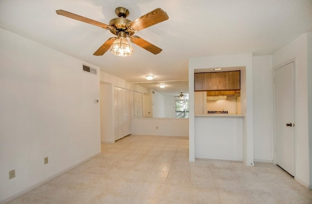 tiled spare room with ceiling fan