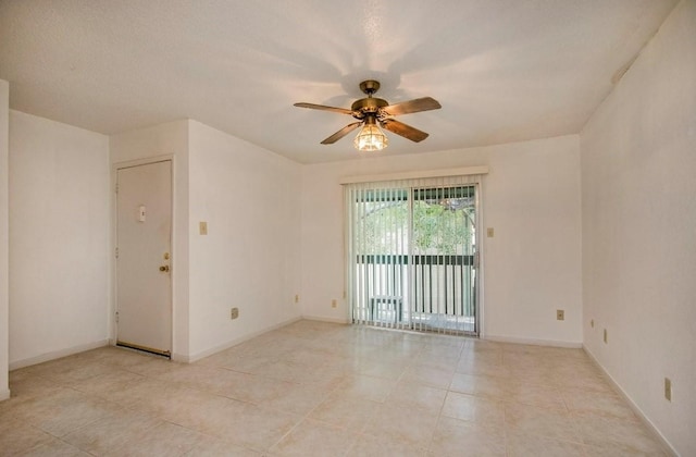 empty room with light tile patterned floors, baseboards, and a ceiling fan