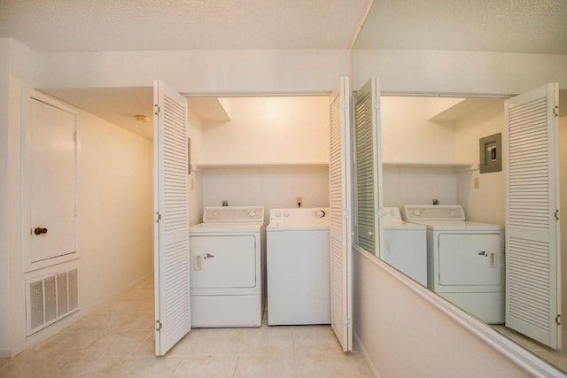 washroom featuring laundry area, electric panel, visible vents, and washer and clothes dryer