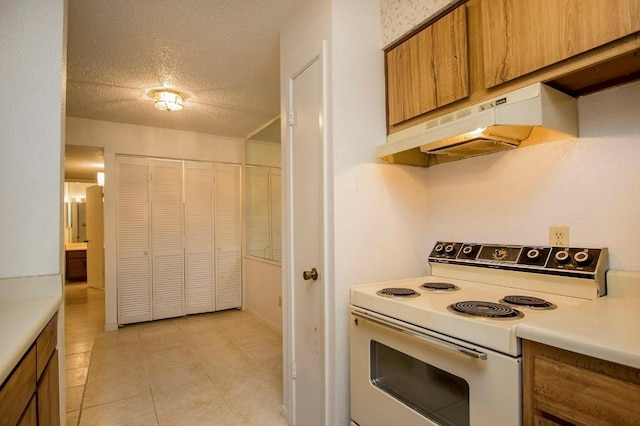 kitchen featuring white electric range oven, brown cabinetry, light countertops, under cabinet range hood, and a textured ceiling