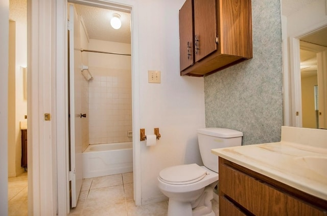 full bathroom with tiled shower / bath, a textured ceiling, tile patterned floors, toilet, and vanity