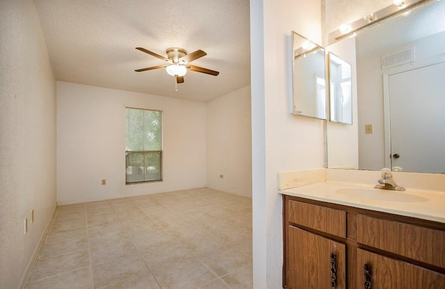 bathroom featuring vanity, a textured ceiling, ceiling fan, and tile patterned floors