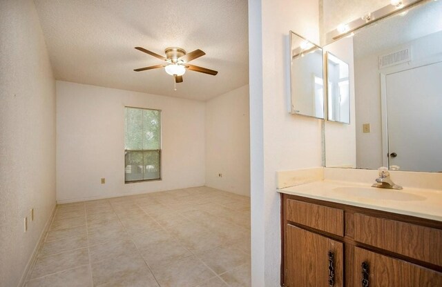 bathroom with vanity, visible vents, ceiling fan, a textured ceiling, and tile patterned floors