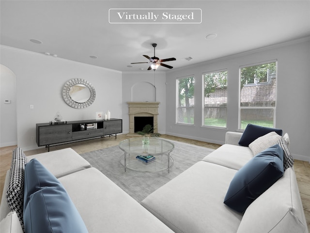 living room featuring ornamental molding, a high end fireplace, and ceiling fan