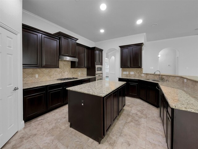 kitchen featuring light tile patterned flooring, crown molding, tasteful backsplash, light stone countertops, and sink