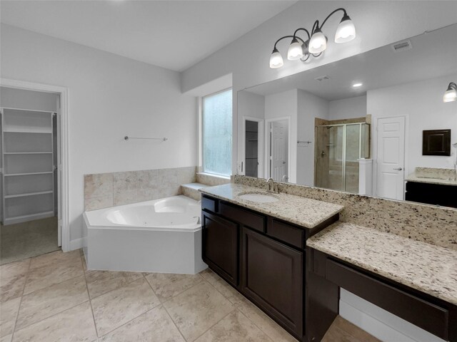 bathroom featuring independent shower and bath, tile patterned floors, and vanity